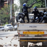 Riot police patrol the street in Harare