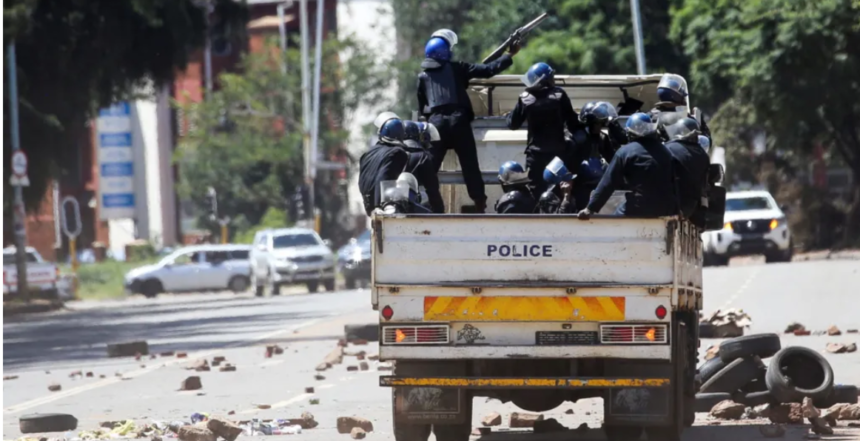 Riot police patrol the street in Harare